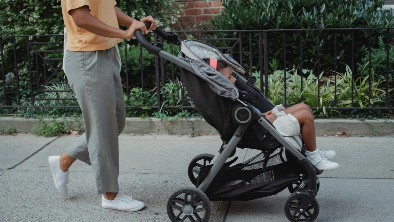 A new mum walking outdoors with a pram